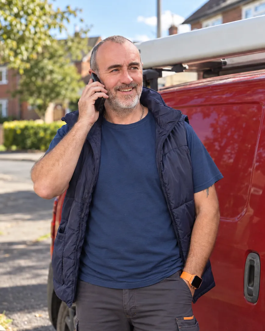 John Hargreaves taking a call beside his van
